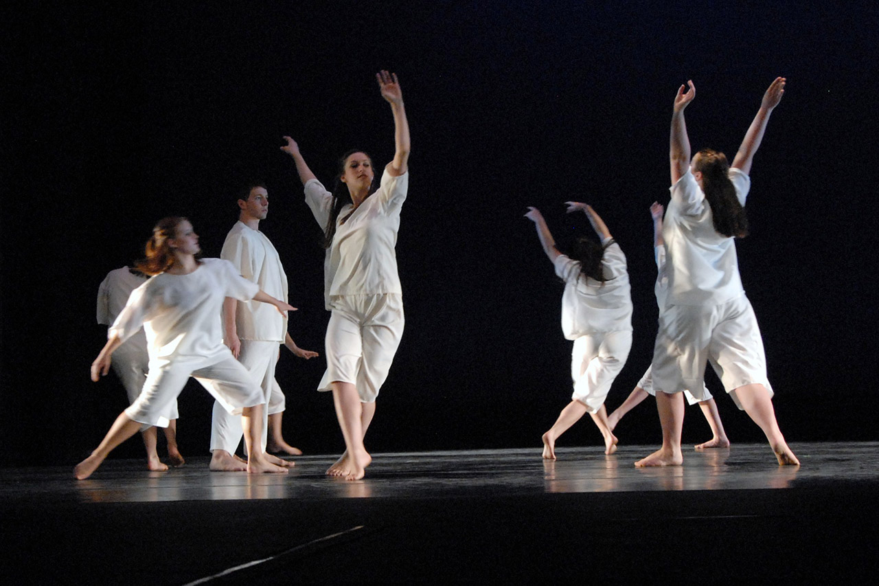 Multiple dancers on stage in white